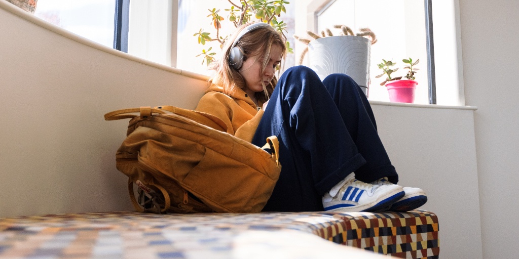 A student sitting on with headphones on/